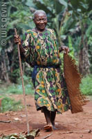 Old Pygmy woman with a mat and a walking stick